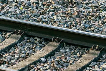 Eine Bahnschiene auf einem geschotterten Gleisabschnitt.